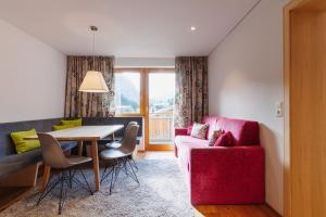 a living room with a table and a red couch at Haus Braunarl in Lech am Arlberg