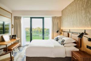 a hotel room with a large bed and a window at The Belfry Hotel & Resort in Sutton Coldfield +80 photos