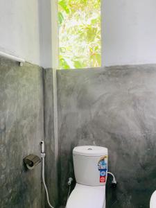 Un baño con inodoro y ventana. en Hidden Well Hiriketiya, en Hiriketiya