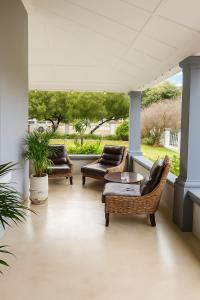 eine Veranda mit 2 Stühlen, einem Sofa und einem Fenster in der Unterkunft The View Guesthouse & Cottage in Caledon