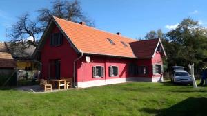a red house with a red roof on a yard at Holiday home in Zalaistvand 27940 in ZalaistvÃ¡nd