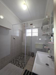 un bagno bianco con doccia e lavandino di Caboodle a Kenton-on-Sea