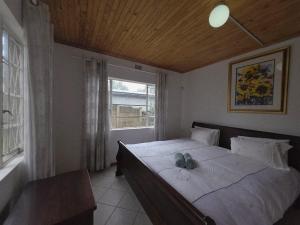 una camera da letto con un letto grande con una grande finestra di Caboodle a Kenton-on-Sea