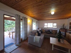 un soggiorno con un divano e un soffitto in legno di Caboodle a Kenton-on-Sea