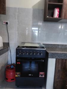 a black stove in a kitchen with a counter at Pavilion Suites in Mombasa +8 photos