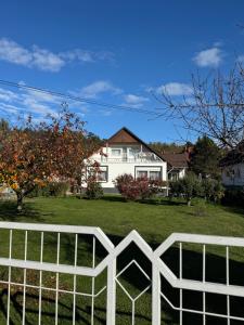 una cerca blanca frente a una casa en Márta Vendégház, en Gyenesdiás