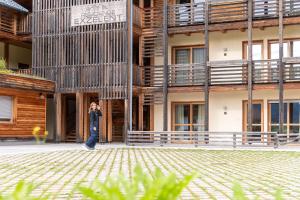 a man walking in front of a building at Mountain Exzelent Residence - Luxury Alpine Apartments in Anterselva di Mezzo