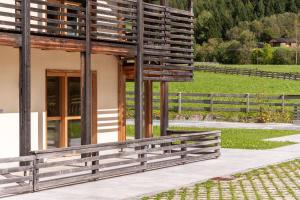 a building with a wooden fence next to a field at Mountain Exzelent Residence - Luxury Alpine Apartments in Anterselva di Mezzo