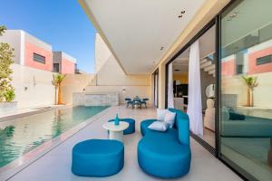 Una sala de estar con sillas azules y una piscina. en Luxury Villa, Design, Comfort, Heated Pool, Games, en Marrakech