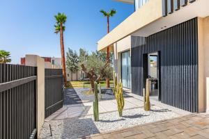 Un patio con palmeras frente a una casa. en Luxury Villa, Design, Comfort, Heated Pool, Games, en Marrakech