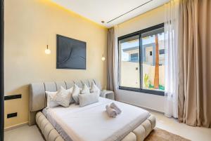 a bedroom with a large white bed and a window at Luxury Villa, Design, Comfort, Heated Pool, Games in Marrakech +32 photos
