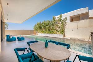 a dining room with a table and chairs next to a swimming pool at Luxury Villa, Design, Comfort, Heated Pool, Games in Marrakech