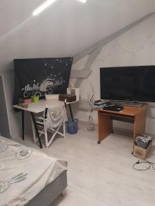 a living room with a desk and a large screen television at Maison Au Bord de l'eau in Loches