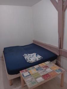 a bed in a room with a table next to it at Maison Au Bord de l'eau in Loches +6 photos