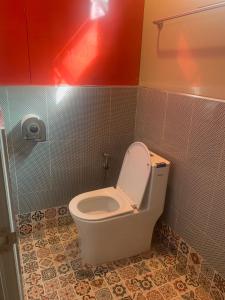 a bathroom with a toilet with the lid up at SriHOME in Ban Don Tum (1)