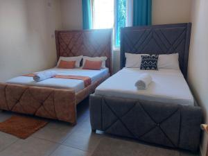 two beds sitting next to each other in a room at Pavilion Suites in Mombasa