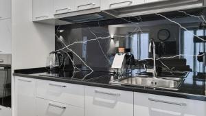 a kitchen with a sink and black counter top at Italianway - Torino 57 A in Milan