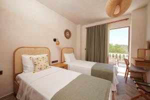 a hotel room with two beds and a balcony at Villa Castelle in Marmaris