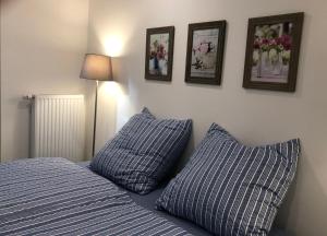 een slaapkamer met twee blauwe kussens en foto's aan de muur bij Ferienchalet Flößwehrtal in Bad Lauterberg