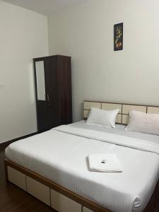 a bedroom with a bed with a book on it at Mount wave Pool villa in Wayanad