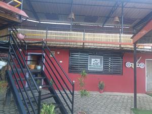 schody prowadzące do czerwonego budynku z oknem w obiekcie Doko Restaurant & Homestay w mieście Heṭauḍā