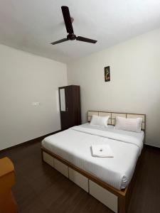 a bedroom with a bed with a ceiling fan at Mount wave Pool villa in Wayanad