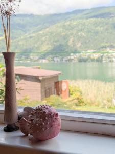 a vase and a plant on a window sill at Seehaus Ossiachersee in Ossiach +27 photos