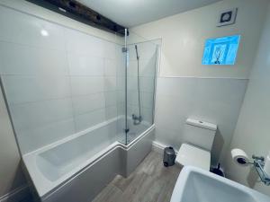 a bathroom with a shower and a toilet and a sink at Kirkgate Cottage - 2 Bedrooms - Sleeps 4 in Cockermouth +23 photos