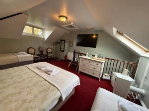 a attic bedroom with two beds and a television at Cambridge Bed & Breakfast in Cambridge