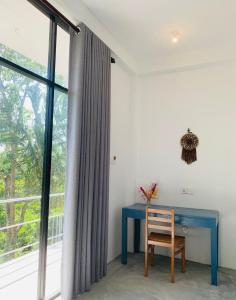 un escritorio azul en una habitación con ventana en Hidden Well Hiriketiya, en Hiriketiya
