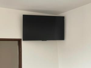 uma TV de tela plana pendurada em uma parede branca em Ubytování u zastávky em Modrá