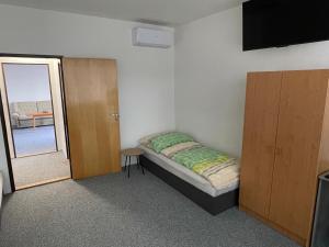 Habitación pequeña con cama y puerta corredera en Ubytování u zastávky, en Modrá