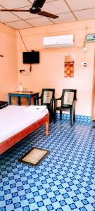 a room with two chairs and a bed and a tv at Blue Bird Residency in Neil Island