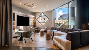 a living room with a couch and a tv at Campanile PRIME - Nice Airport in Nice