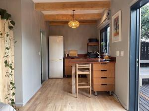 eine Küche mit einem Kühlschrank und einem Tisch mit einem Stuhl in der Unterkunft Olive Cottage Scarborough Seaside Village in Scarborough + 9 Fotos