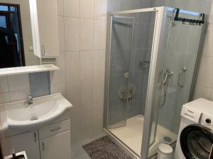 uma casa de banho com um chuveiro, um lavatório e uma máquina de lavar roupa em Ubytování u zastávky em Modrá mais 38 fotografias