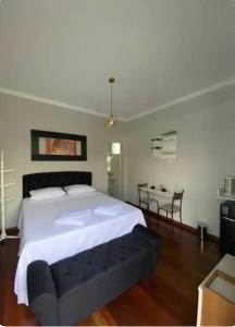 a bedroom with a large bed and a table at Hospedagem Altas da Quitéria Suíte 01 in Catas Altas