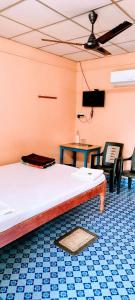 a room with a bed and a table and chairs at Blue Bird Residency in Neil Island