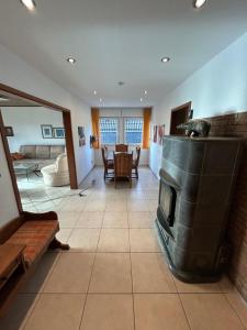 un soggiorno con camino e tavolo di Ferienwohnung Hocheifelblick a Reifferscheid