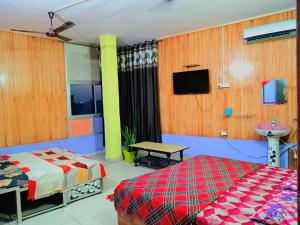 a bedroom with a bed and a tv on the wall at Stacy Guest House in Jīnd