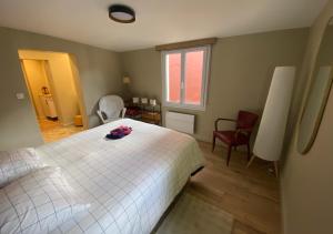 La Lucienne - Cœur de ville avec un extérieur في مونتروي-سور-مير: غرفة نوم بسرير ابيض وكرسيين