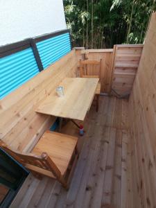 eine Holzterrasse mit einem Holztisch und einer Bank in der Unterkunft Nedokoro Minamihama Kujukuri - Vacation STAY 98351v in Kujukuri