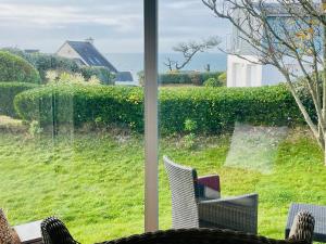 a window with a view of a yard at " Goarem Bihan" Villa de Charme Front de Mer in Plouarzel