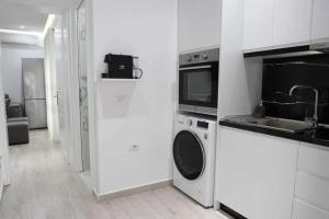 a kitchen with a washing machine and a microwave at Vaip House B in Berat +10 photos