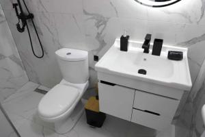 a white bathroom with a toilet and a sink at Vaip House B in Berat