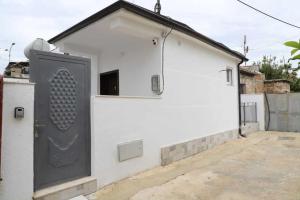 a white building with a black door on it at Vaip House B in Berat