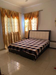 a large bed in a room with windows at Apartment Brusubi in Mbarra Kunku