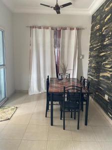 a dining room table with chairs and a ceiling fan at Apartment Brusubi in Mbarra Kunku