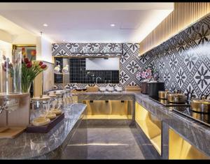 a kitchen with a large counter with a counter top at Xingcheng Beijing Huilongguan Jishuitan Hospital Hotel in Beijing