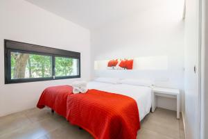 een witte slaapkamer met een rode deken op een bed bij Dalt Son Morro in Santa Margalida +29 foto's